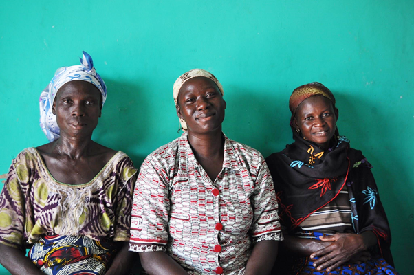 Three Ghanaian women sit side-by-side. 