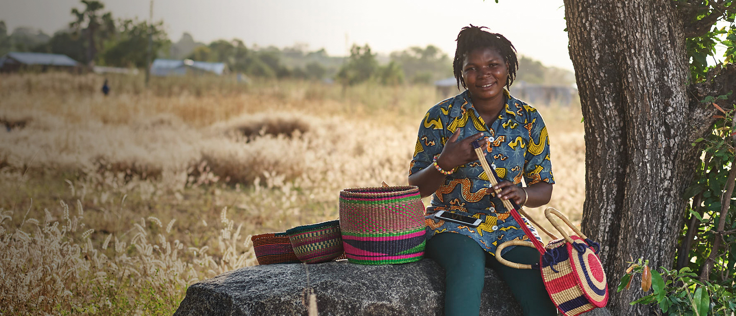 Dorcas_sits_outside_with_collection_of_baskets_-_CAMFED_basket_prize_draw_-_August_2020_-_Hero_Image