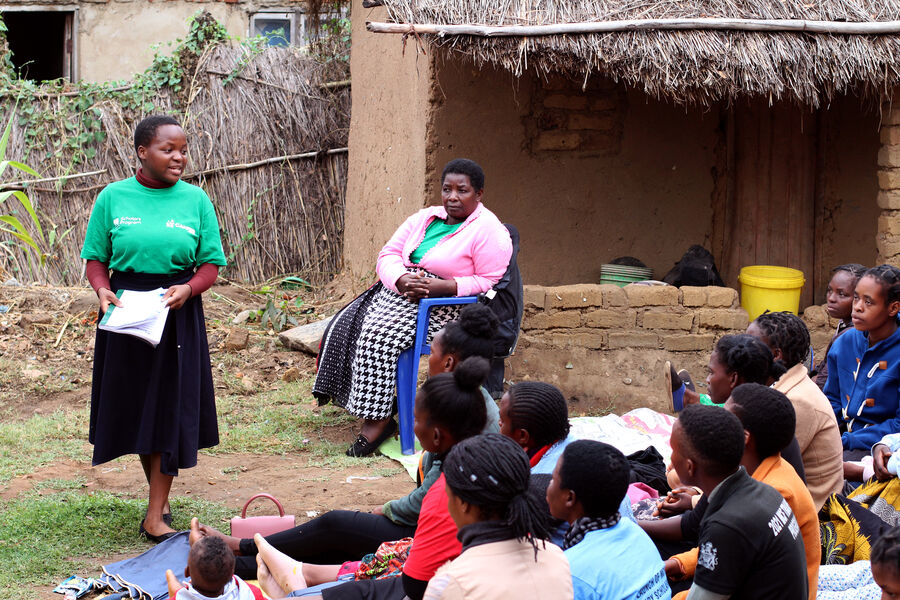 A young Malawin woman addresses a crowd in her community.